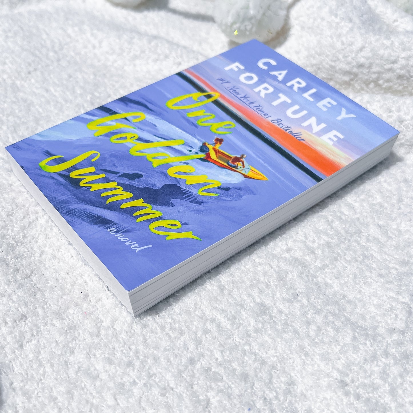 Book titled 'Dark Golden Summer' by Carley Fortune on a textured white surface