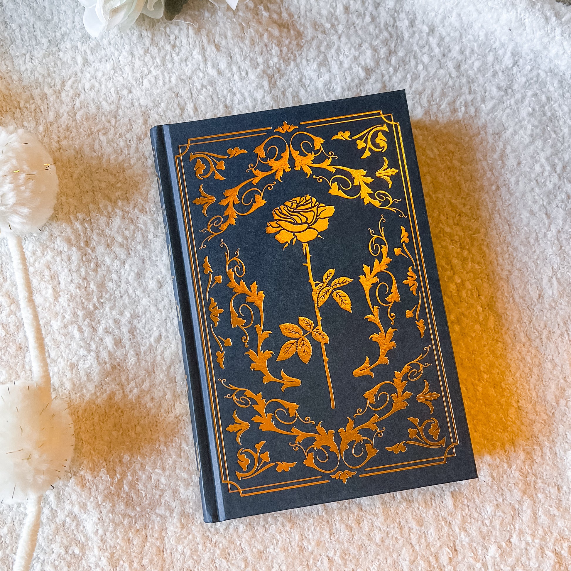Decorative notebook with gold floral design on a textured surface