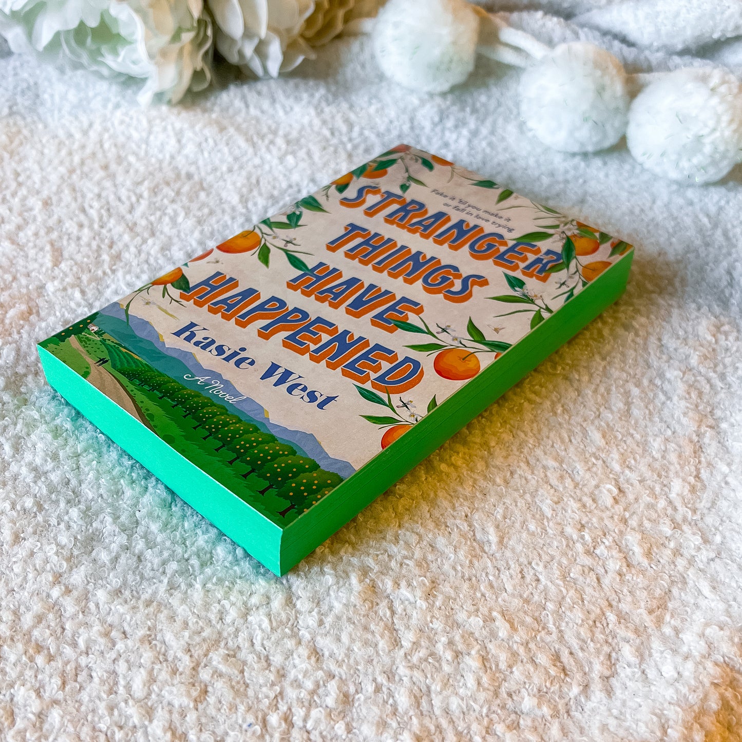 The book “stranger things have happened” with a rural design on a textured white surface