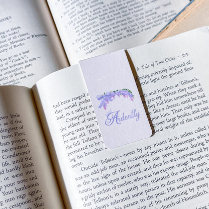 Open book with a bookmark featuring a purple flower design and the word 'Ardently'.