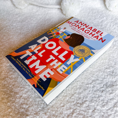 Book titled 'Dolly All the Time' by Annabel Monaghan on a textured surface