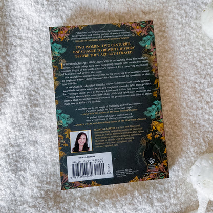 The back cover of the book 'Two Women, Two Centuries: One Chance to Rewrite History Before They Are Both Erased' by Marianna Martinez, displayed on a textured white faux fur surface.