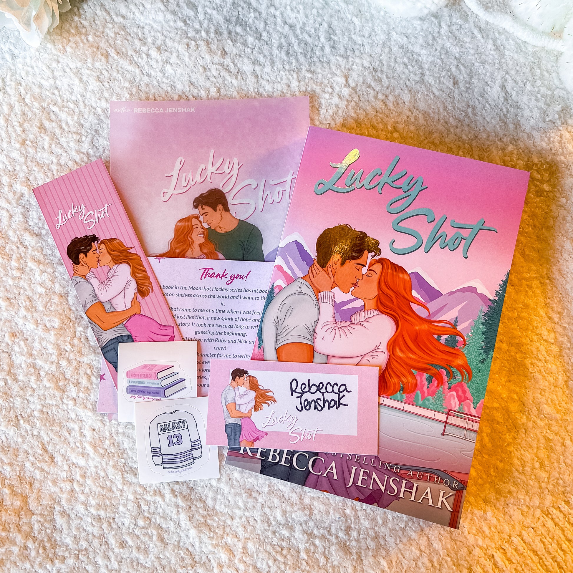 Book packaging for 'Lucky Shot' by Rebecca Jenshak with a romantic illustration on a pink background.