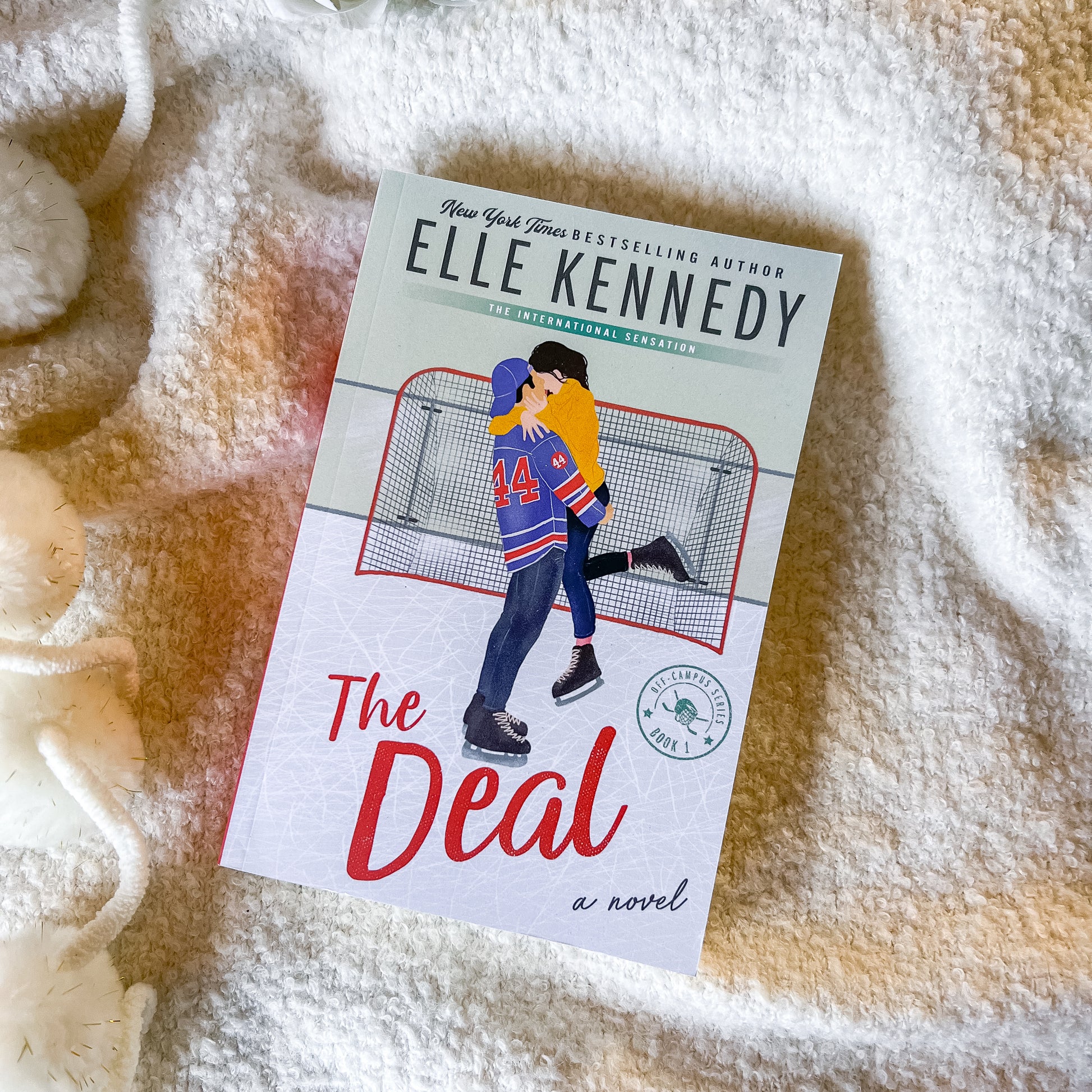 Book titled 'The Deal' by Elle Kennedy on a textured surface