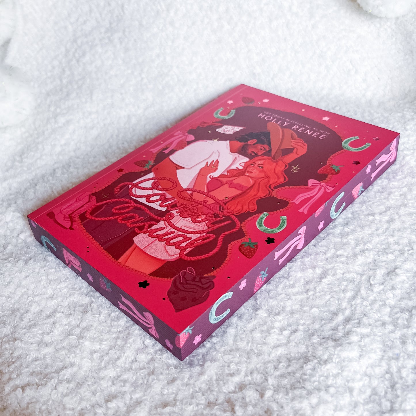 Pink and red book with illustrations on a textured white surface
