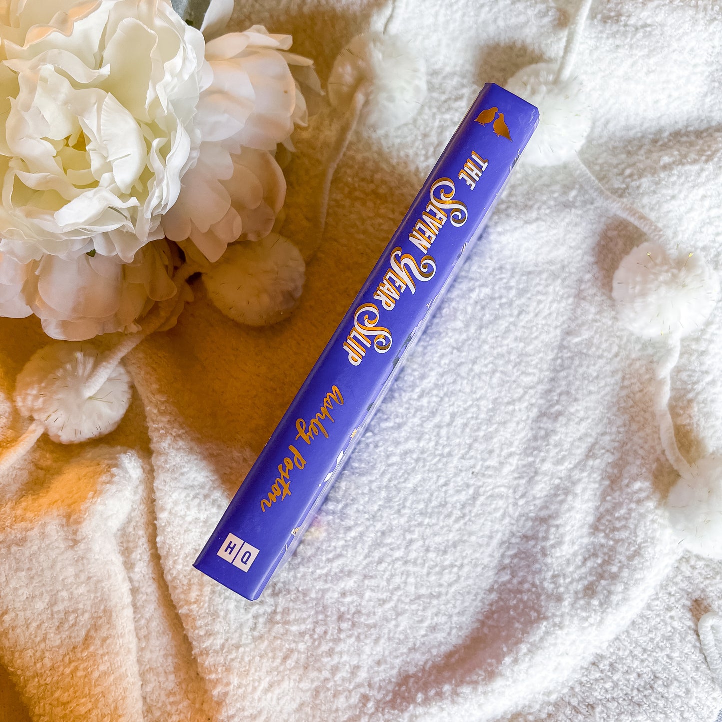 Book spine with gold text on a textured surface with flowers