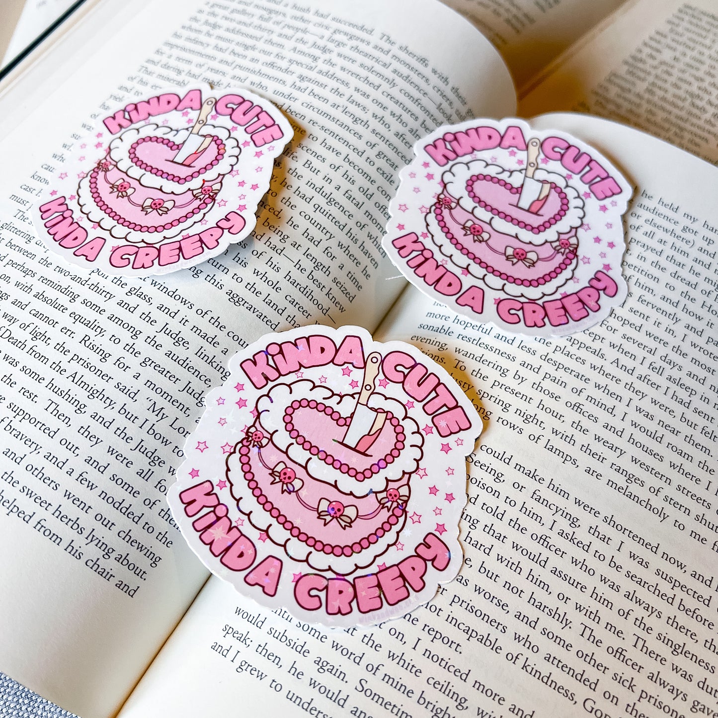 Three 'Kinda Cute Kinda Creepy' stickers on an open book