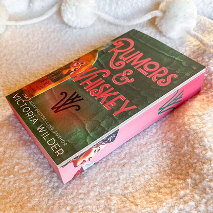 Book titled 'Rumors & Whiskey' by Victoria Wilder on a textured surface