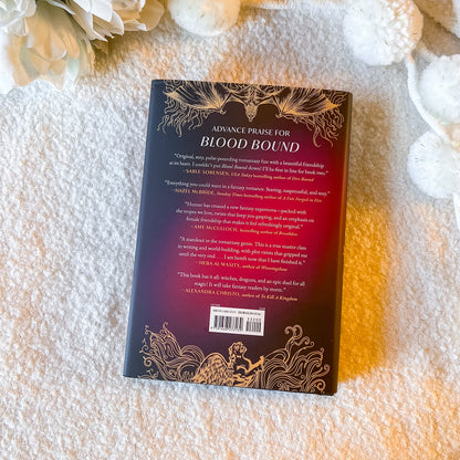 Book titled 'Blood Bound' on a textured surface with flowers.