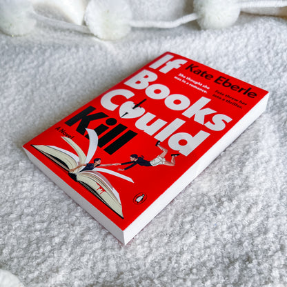 The book 'If Books Could Kill' by Kate Eberle lies on a textured white blanket. The cover is bright red with bold white and black typography and an illustration of a person falling off an open book.