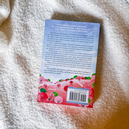 Back of a book with a pink and red design on a textured surface