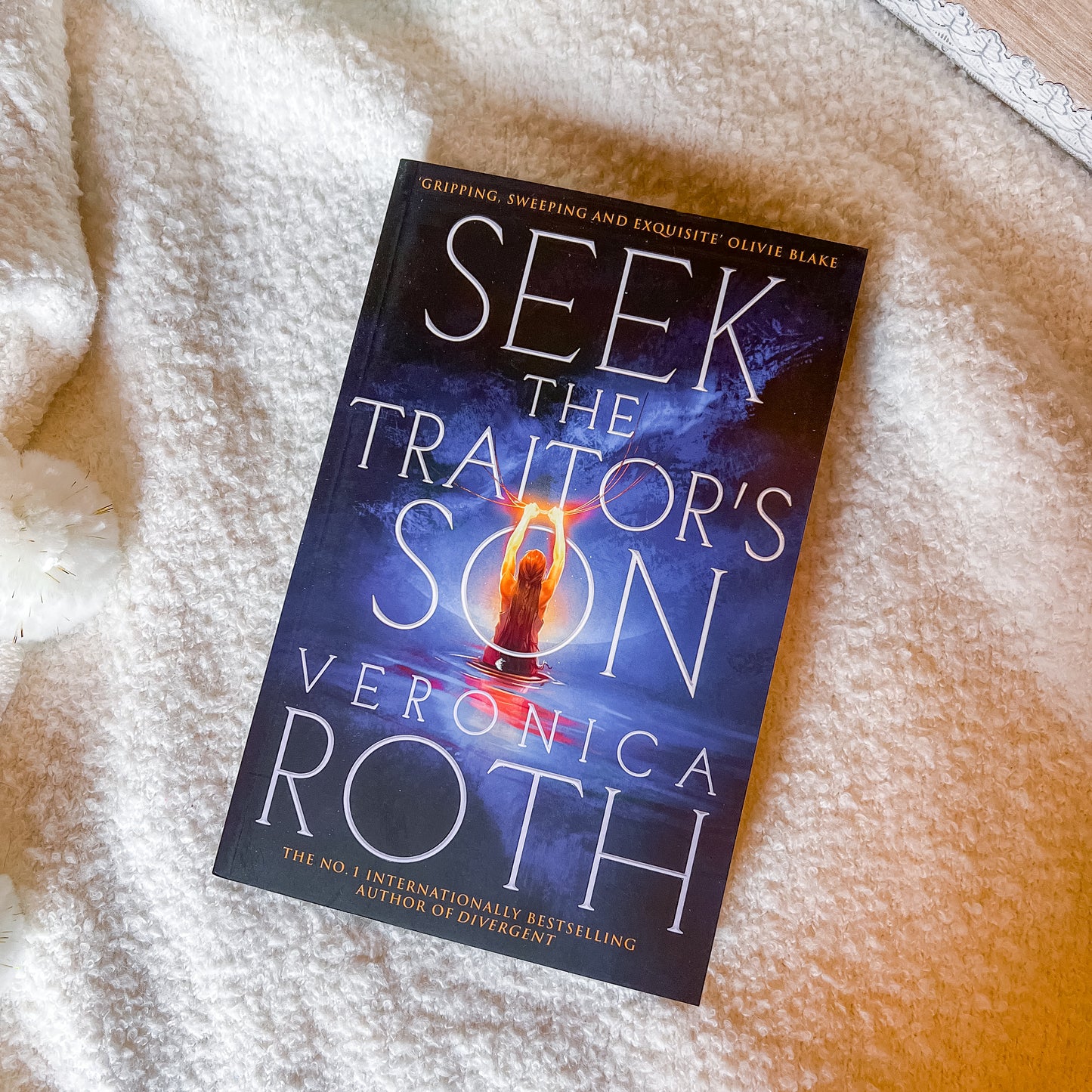 Book titled 'Seek the Traitor's Son' by Veronica Roth on a textured surface