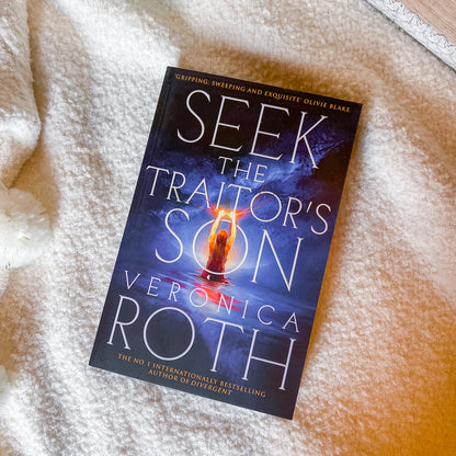 Book titled 'Seek the Traitor's Son' by Veronica Roth on a textured surface