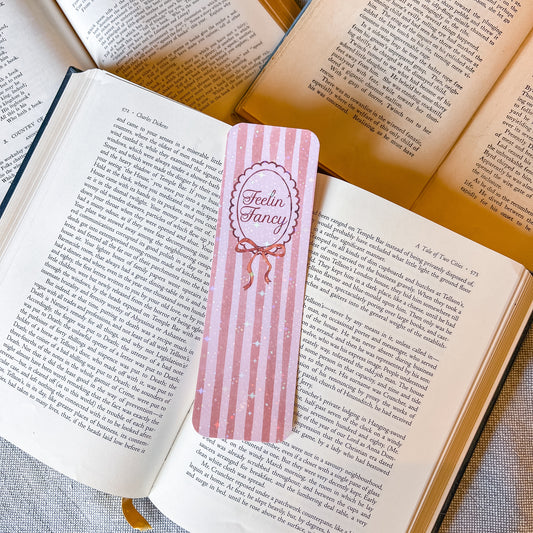 Pink striped bookmark with 'Feelin' Fancy' text on an open book