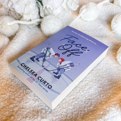 Book titled 'Face Off' by Chelsea Curto on a soft, textured surface with white flowers.