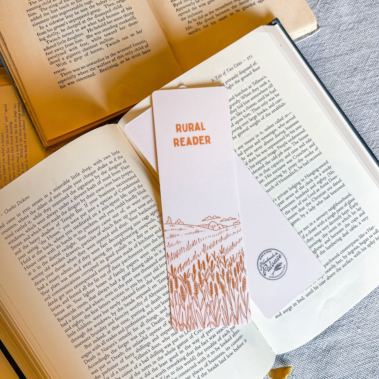 Open book with a 'Rural Reader' bookmark featuring a wheat design on a textured surface.