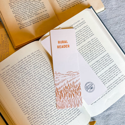 Open book with a 'Rural Reader' bookmark featuring a wheat design on a textured surface.