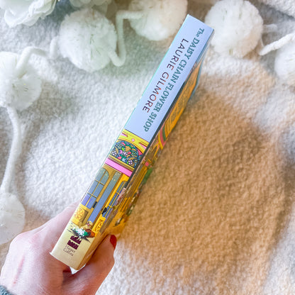 Book spine of "the daisy chain flower shop" on a textured white background