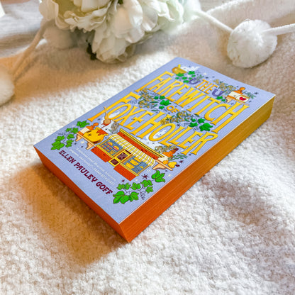 A book titled 'The Honeyhole' by Ellen Pavlev Goff, featuring a colorful illustrated cover, resting on a textured white blanket with white flowers in the background.