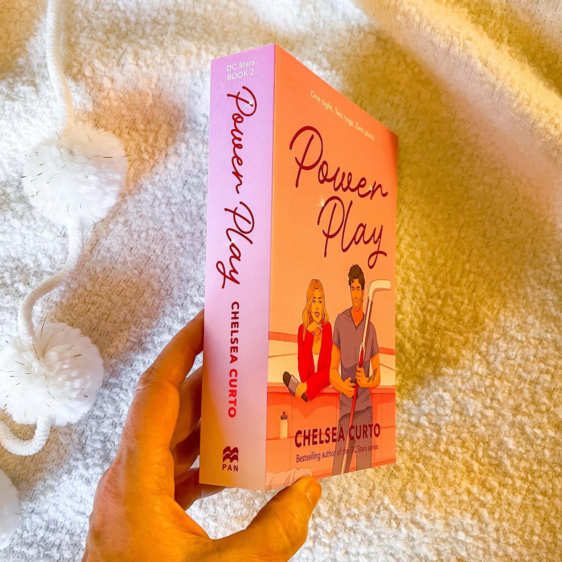 Book titled 'Power Play' by Chelsea Curto held in a hand against a textured background