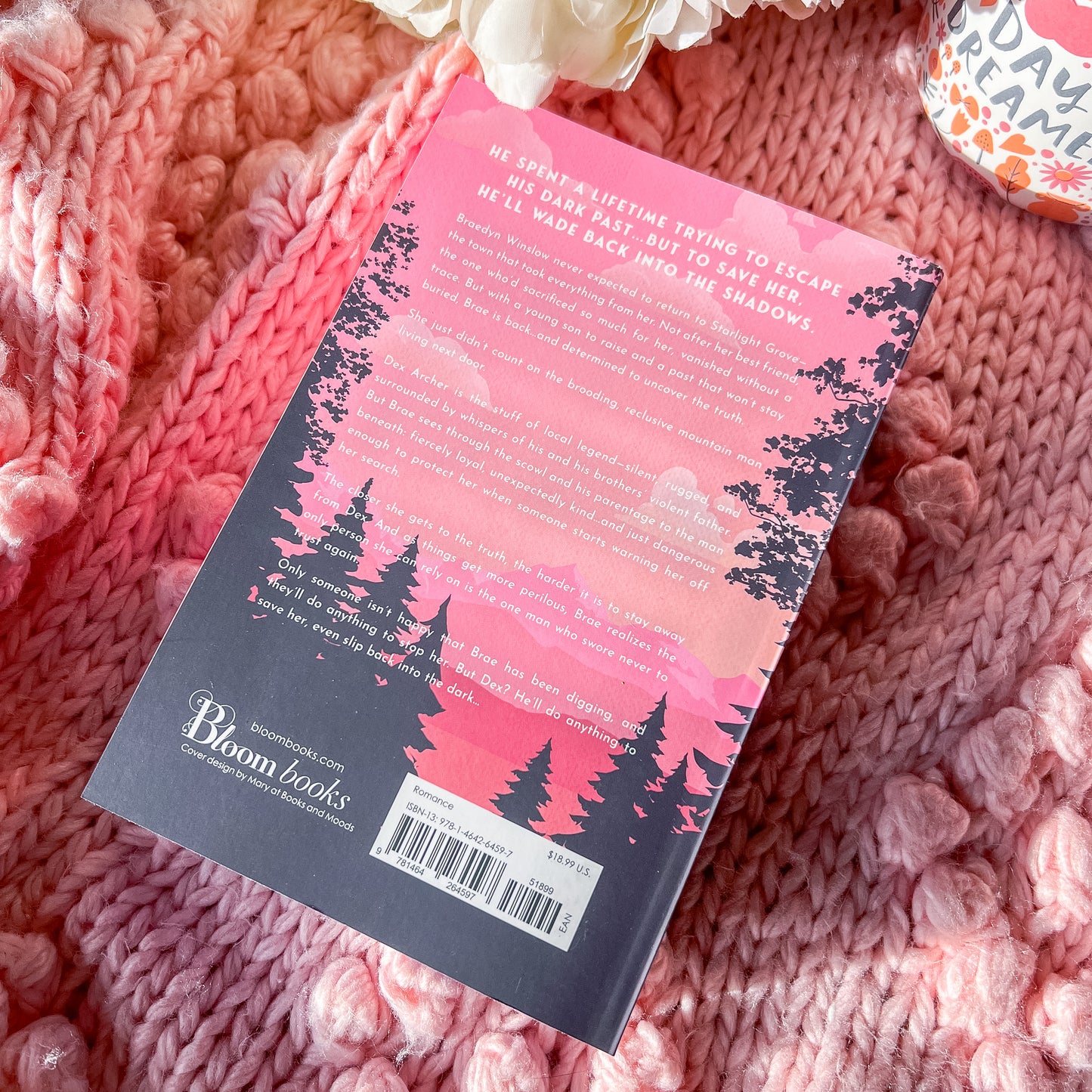 Book with a pink and black cover on a pink textured surface