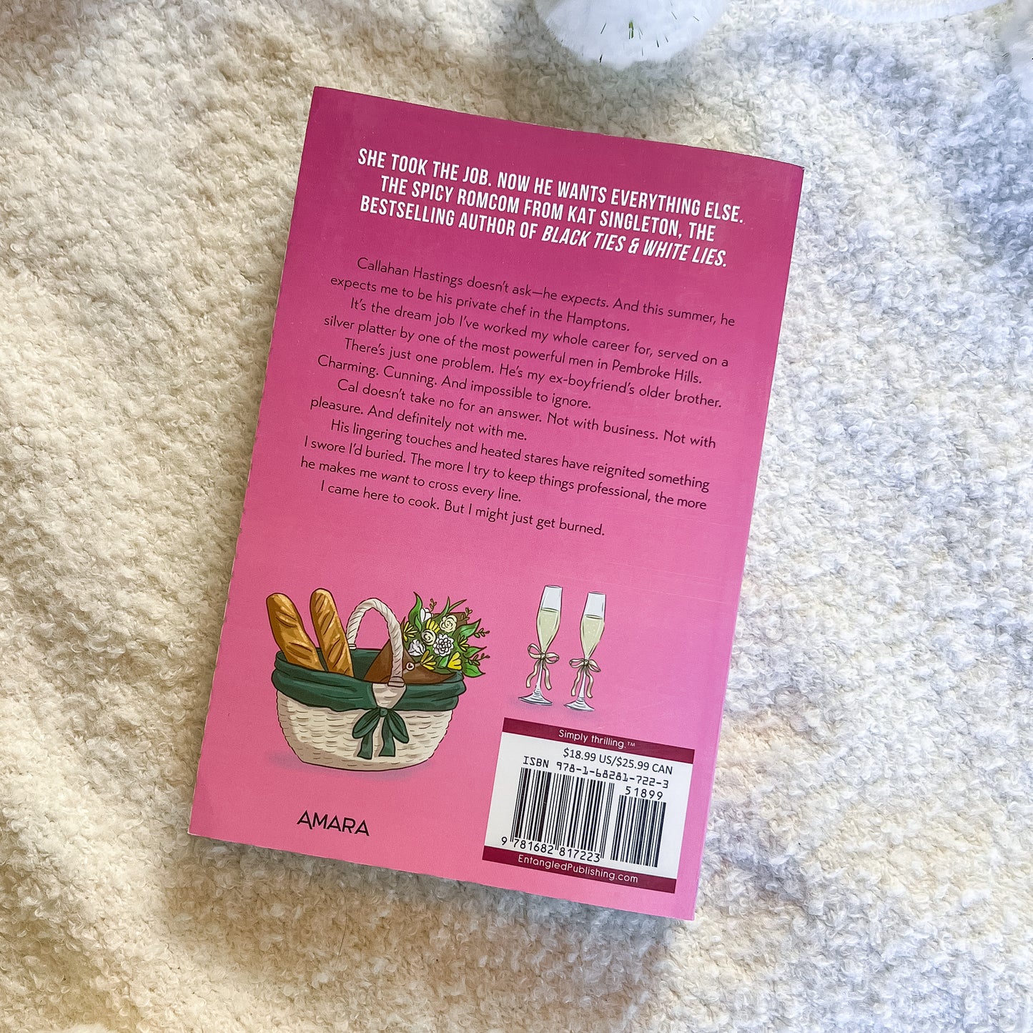 Pink book cover with text and illustrations on a textured surface