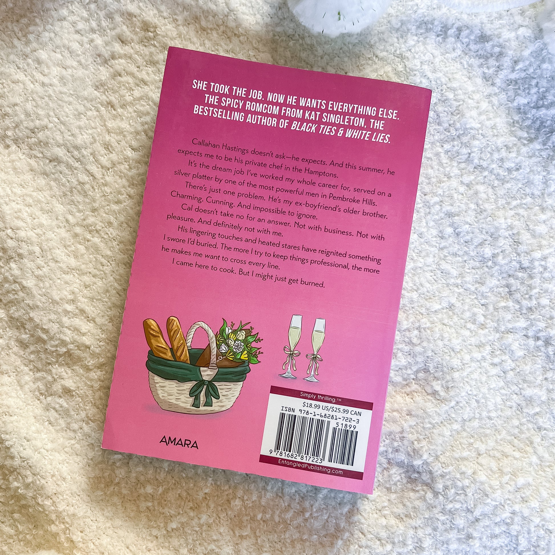 Pink book cover with text and illustrations on a textured surface