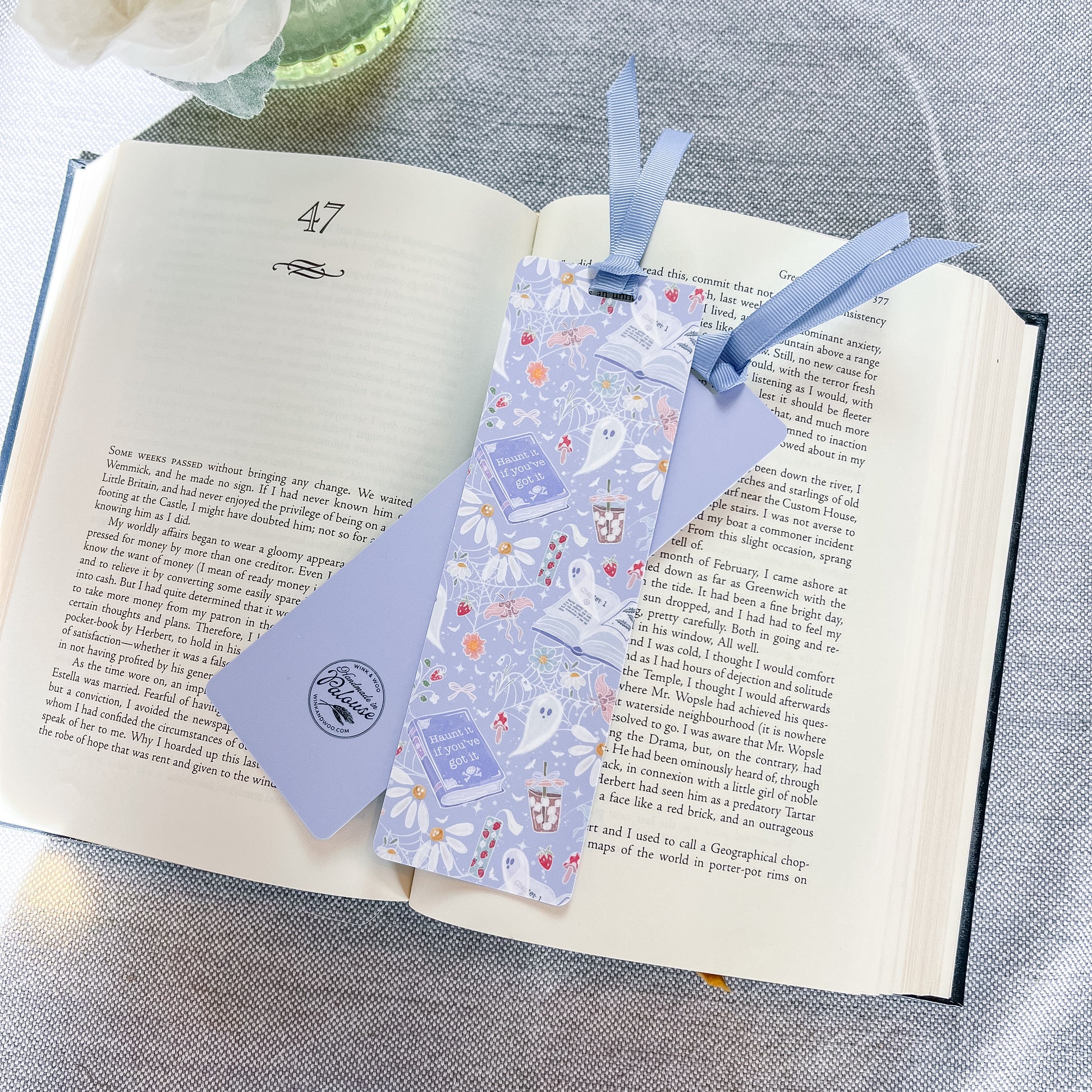 Blue bookmark with a ghost design on top of a book