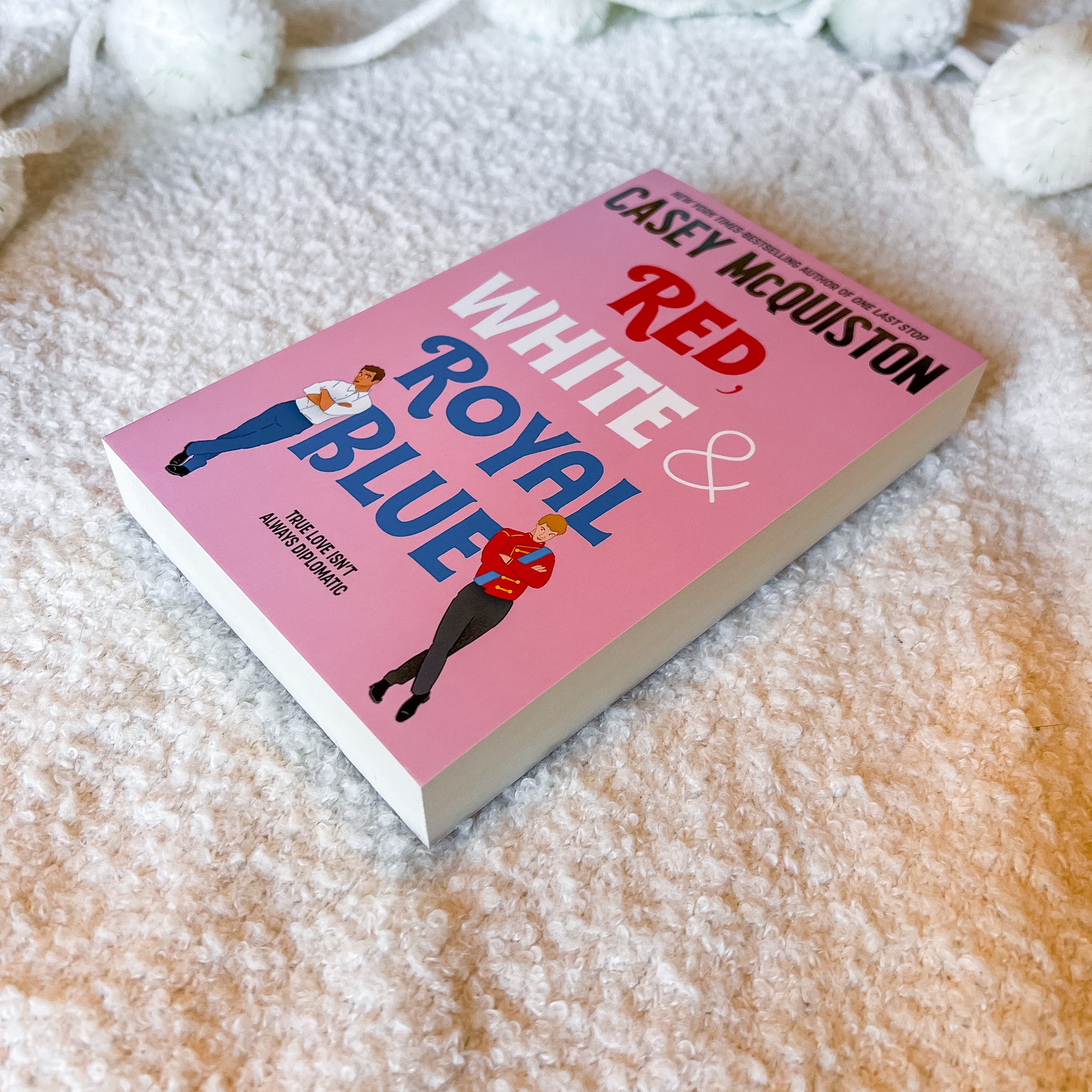 Book titled 'Red, White & Royal Blue' by Casey McQuiston on a white background