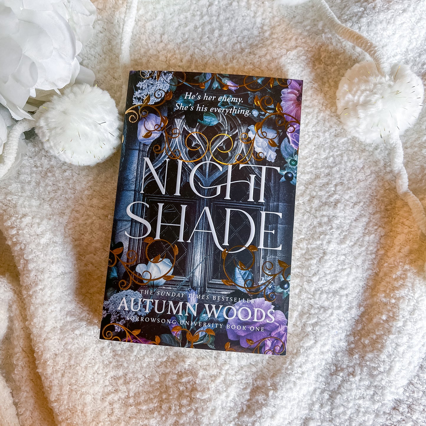 Book titled 'Nightshade' by Autumn Woods on a textured surface with decorative elements.