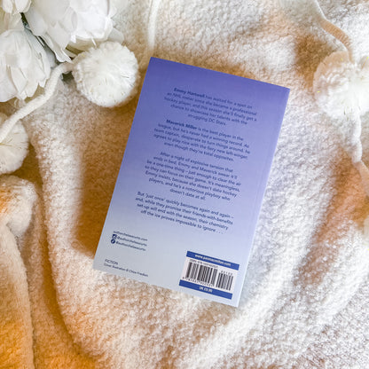 Book with a purple back cover on a textured surface with white flowers