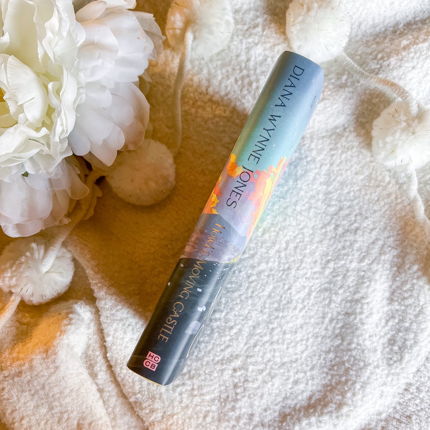 Dana Wynne Jones mascara tube on a textured surface with white flowers