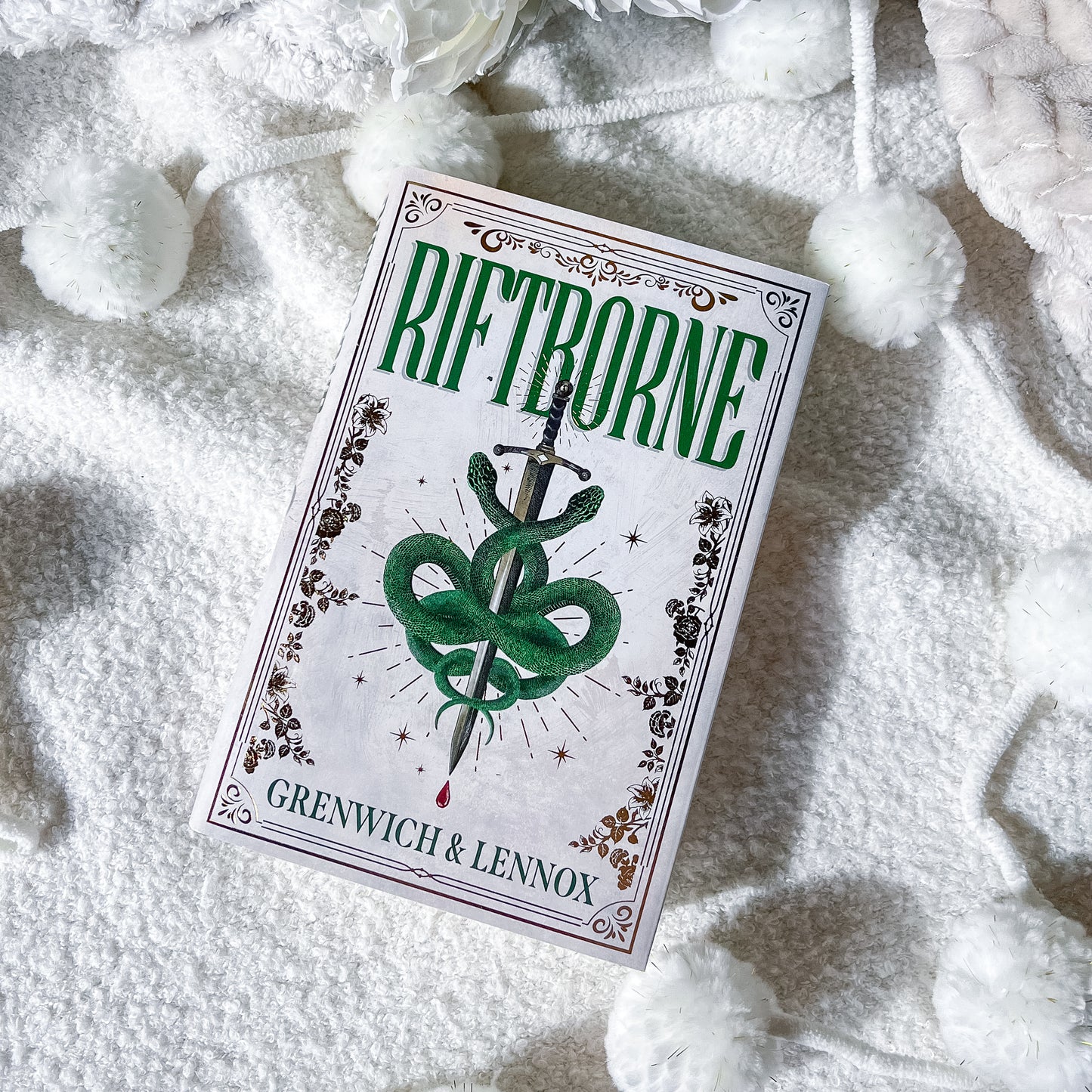 Riftborne book with green snake design on a white textured surface