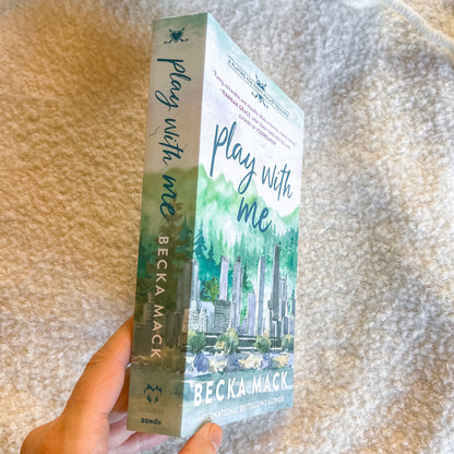 Book titled 'Play with Me' by Becka Mack held against a textured beige background