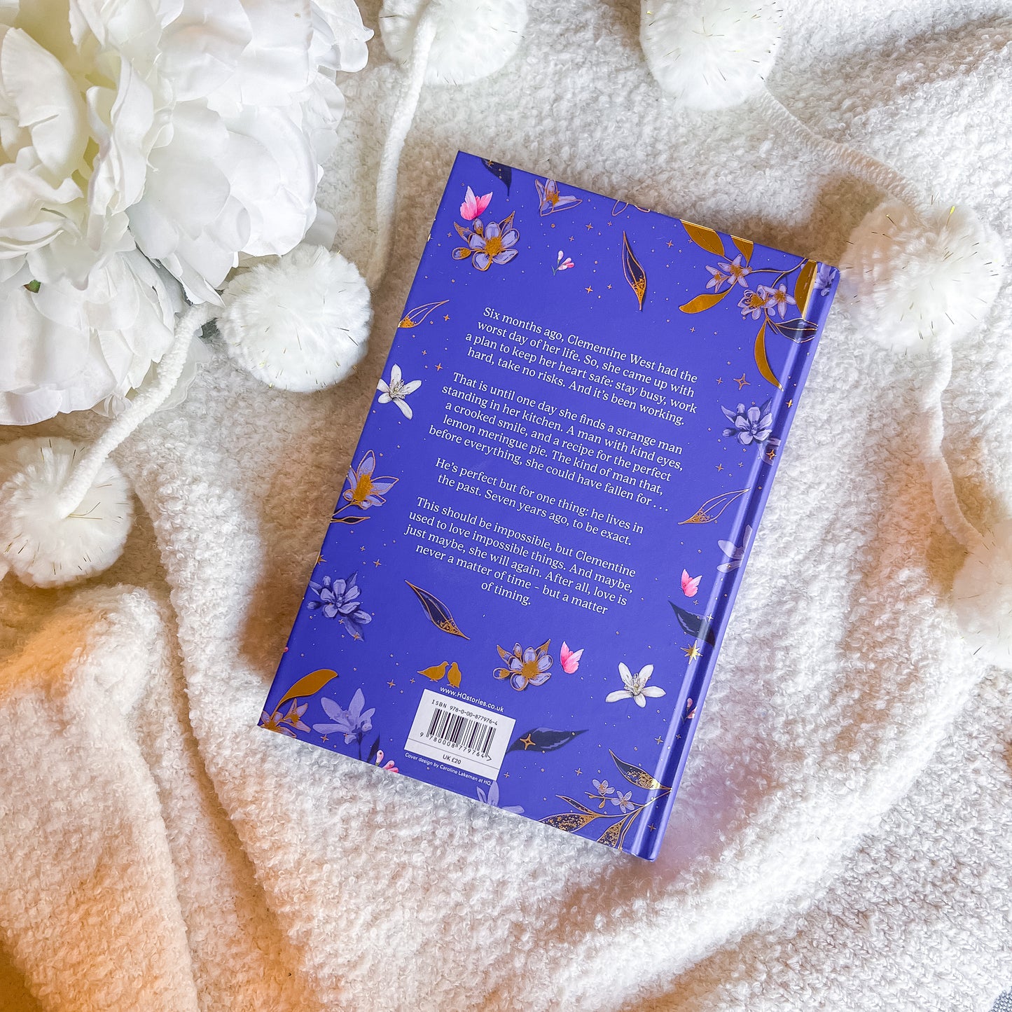 Book with floral design on a textured surface with white flowers