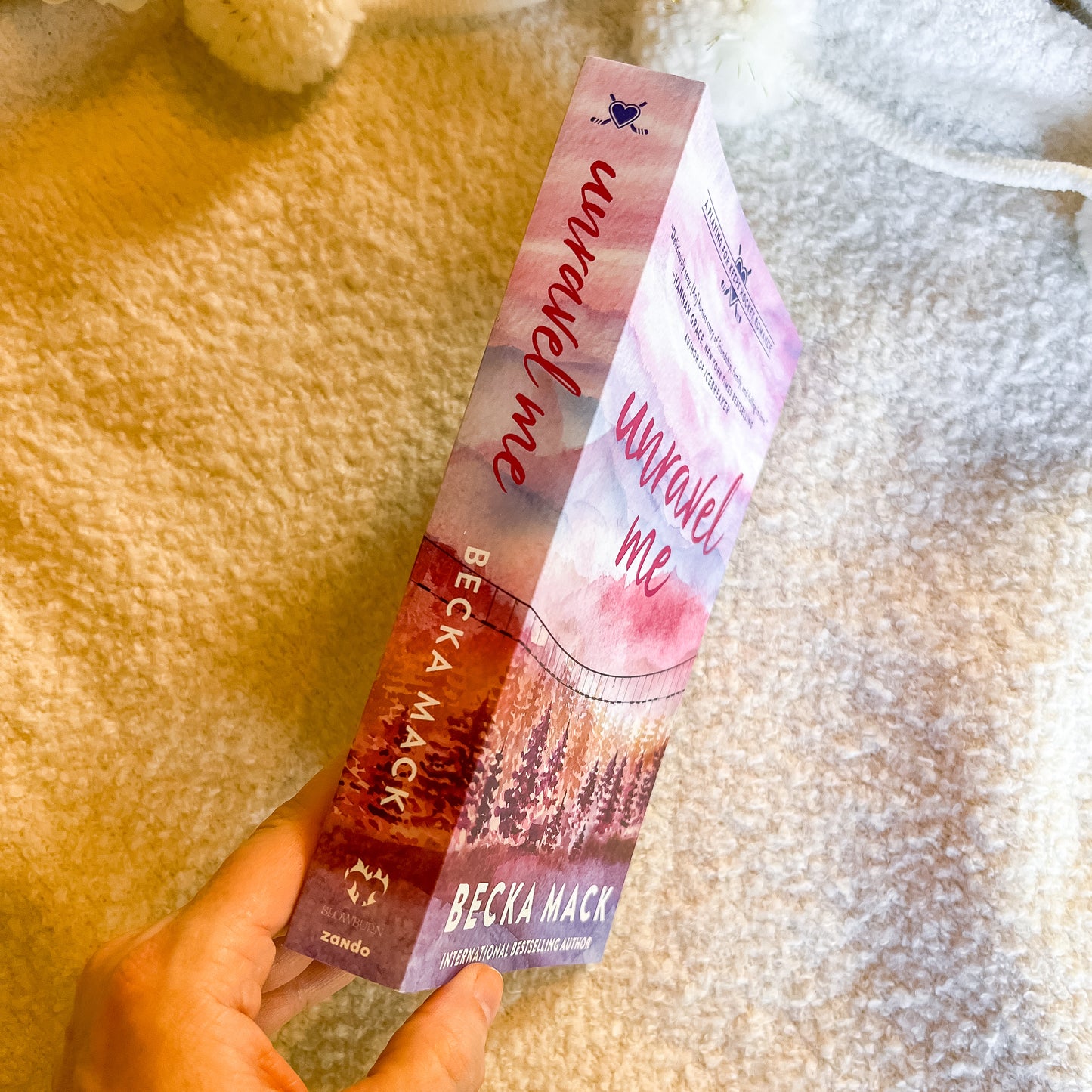 Two books titled 'Unravel Me' by Becka Mack held against a textured background.
