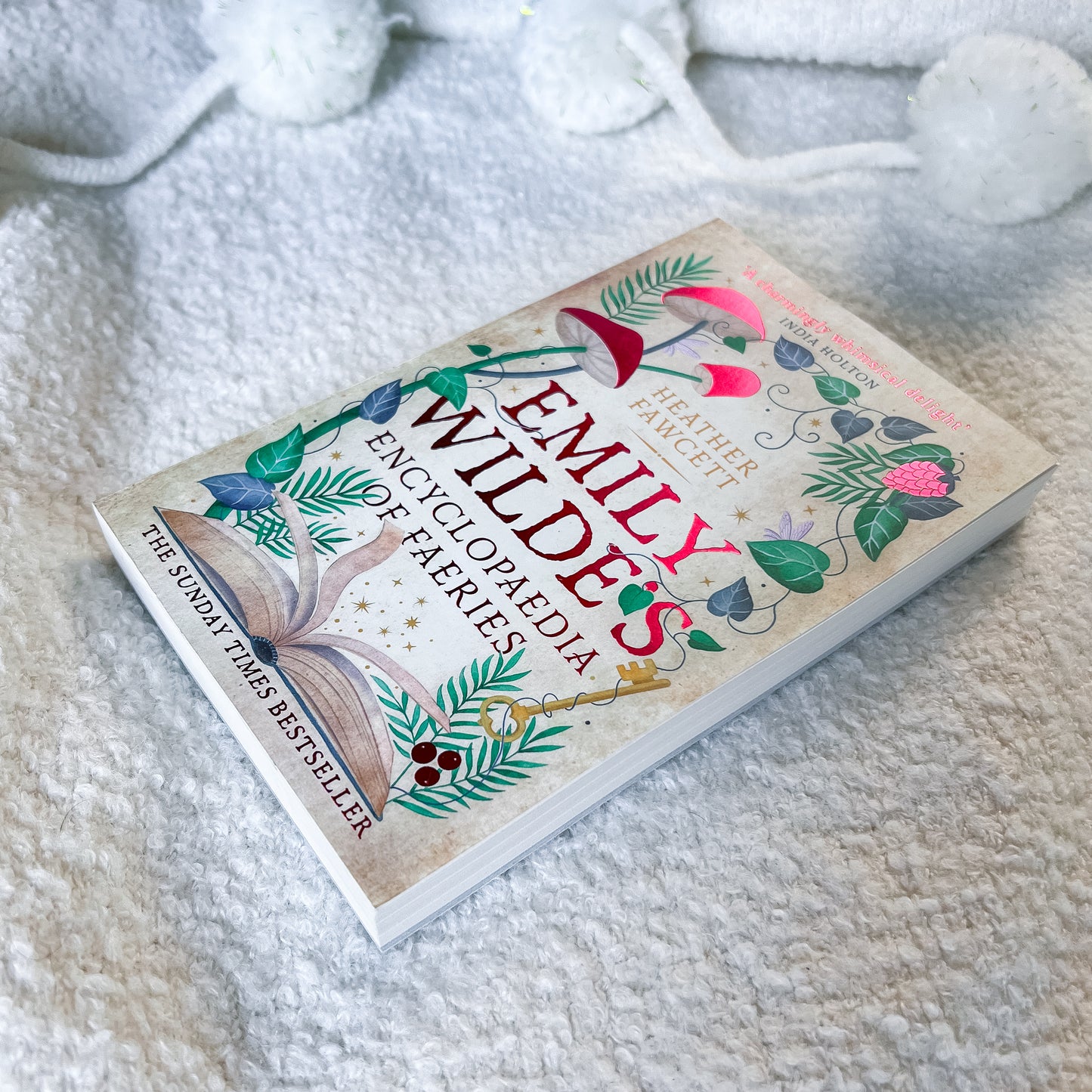Book titled 'Emily Wilde's Encyclopaedia of Faeries' on a soft, textured surface.
