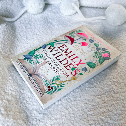 Book titled 'Emily Wilde's Encyclopaedia of Faeries' on a soft, textured surface.