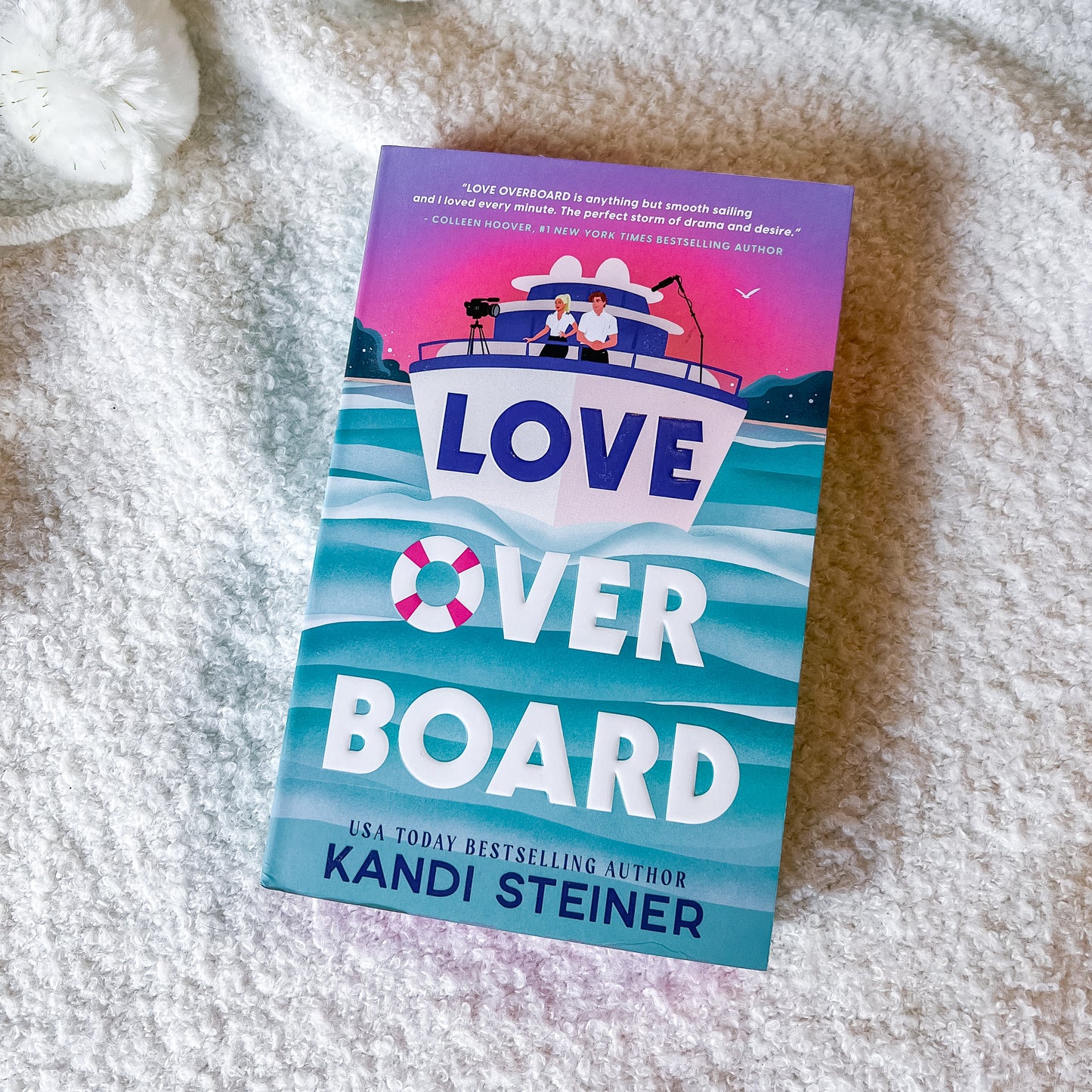Book titled 'Love Over Board' by Kandi Steiner on a textured surface