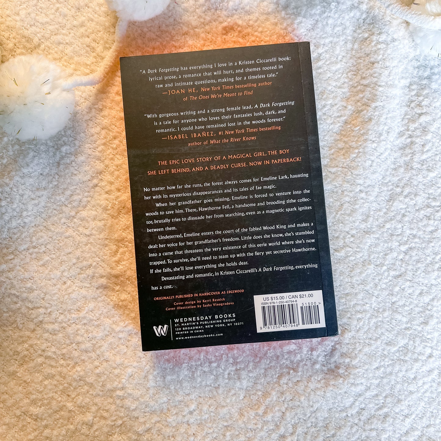 The back cover of the book 'A Del Forgiving' by Kristen Clifton is shown lying on a textured white blanket. The cover is black with white text and features a barcode at the bottom right.