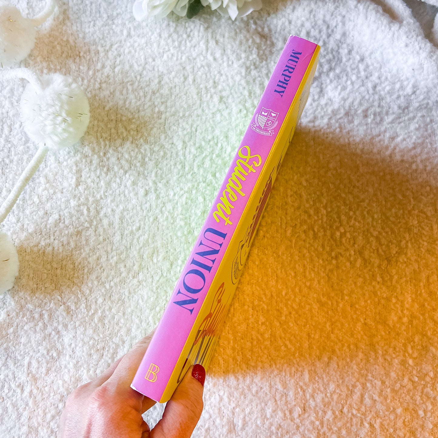 Book cover of 'The Undergrads Student Union' by Julie Murphy with a yellow and pink design.