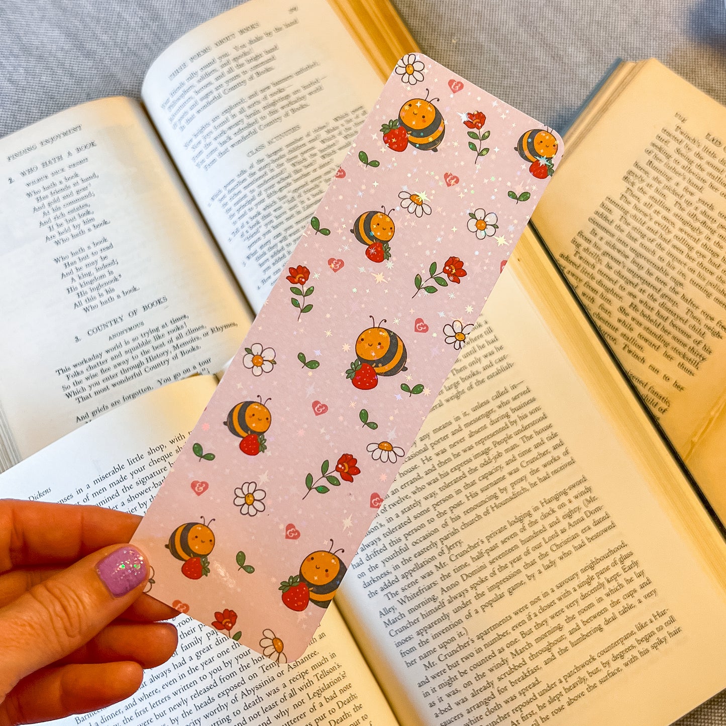 Decorative bookmark with cartoon characters held over an open book