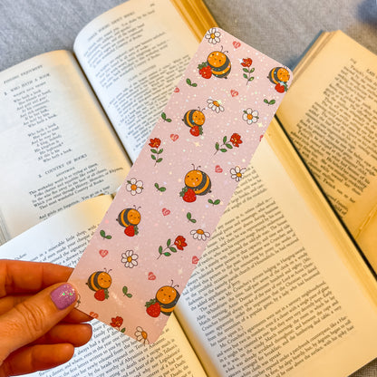 Decorative bookmark with cartoon characters held over an open book
