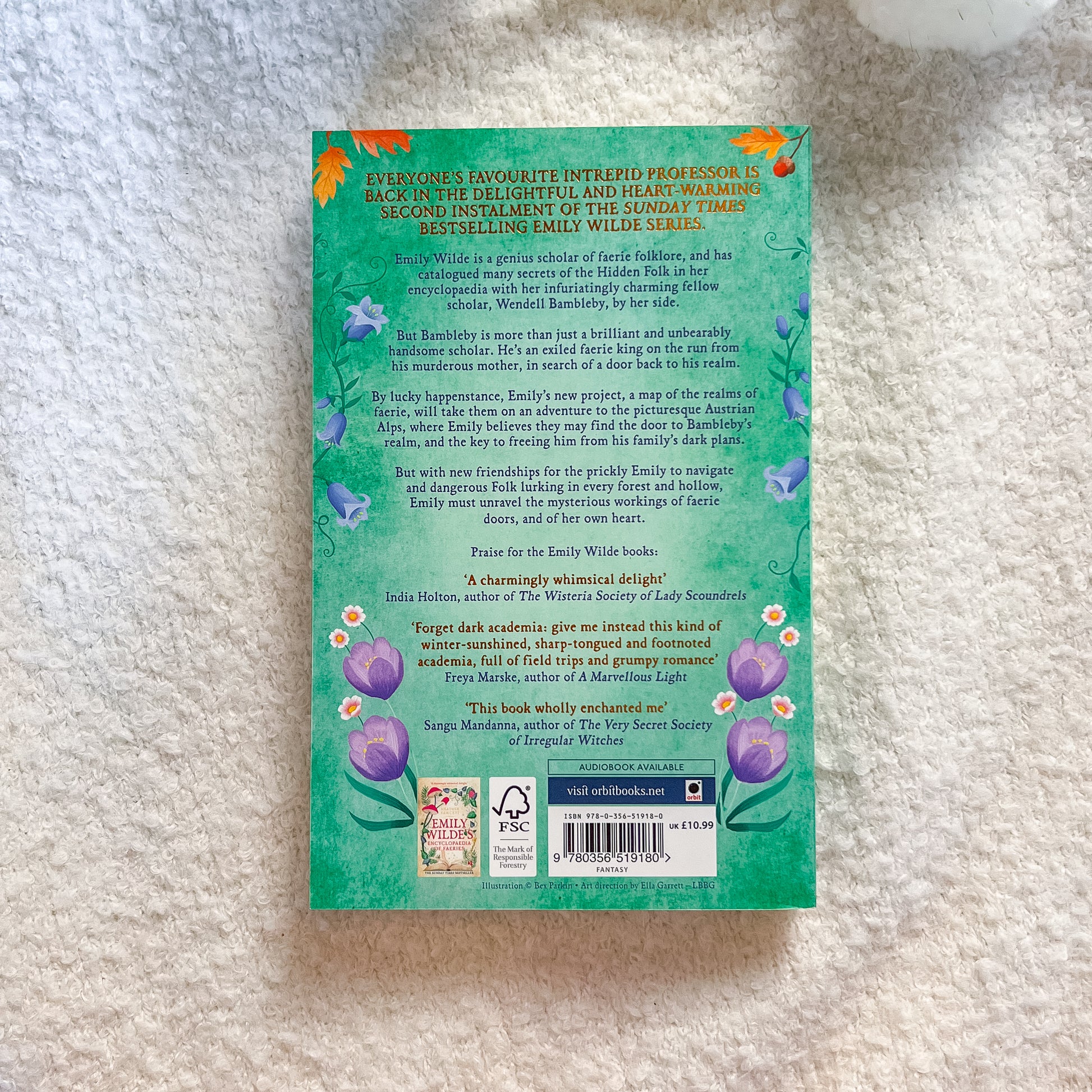 Book back cover with text and floral designs on a textured surface