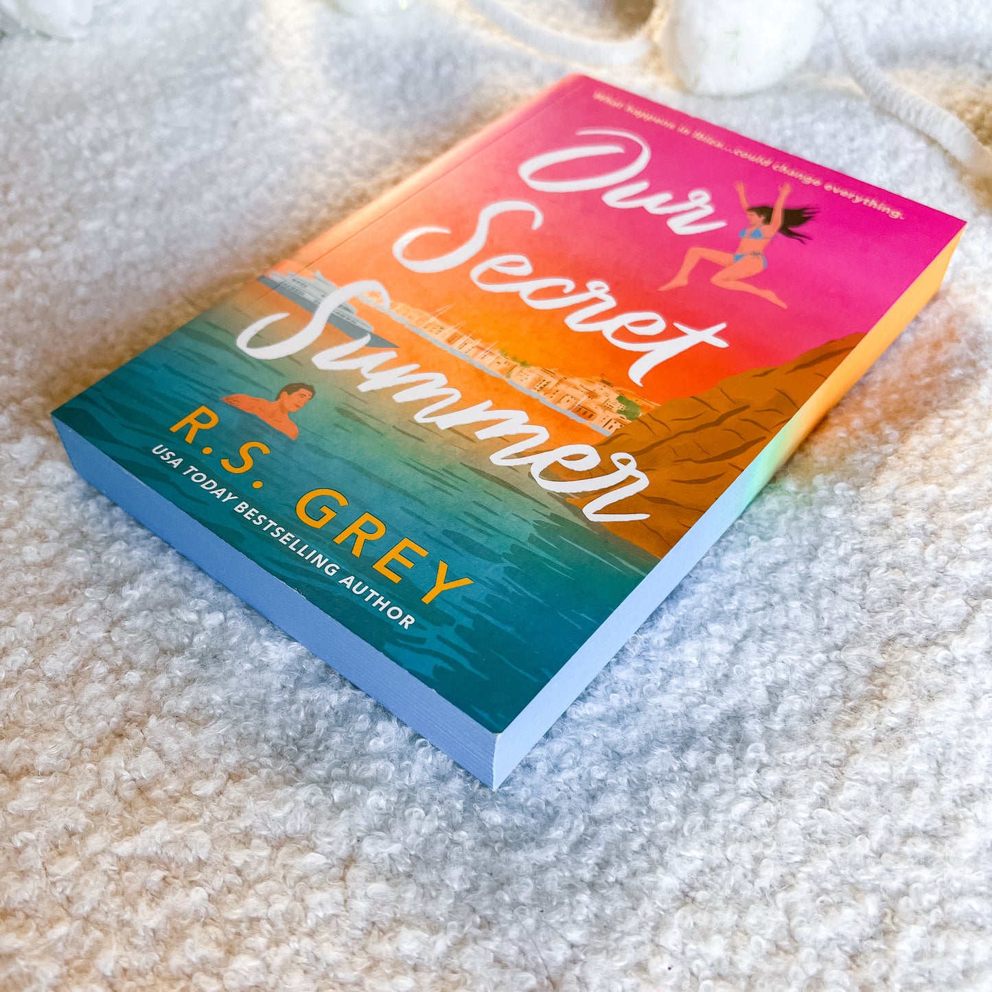Book titled 'Our Secret Summer' by R.S. Grey on a textured surface