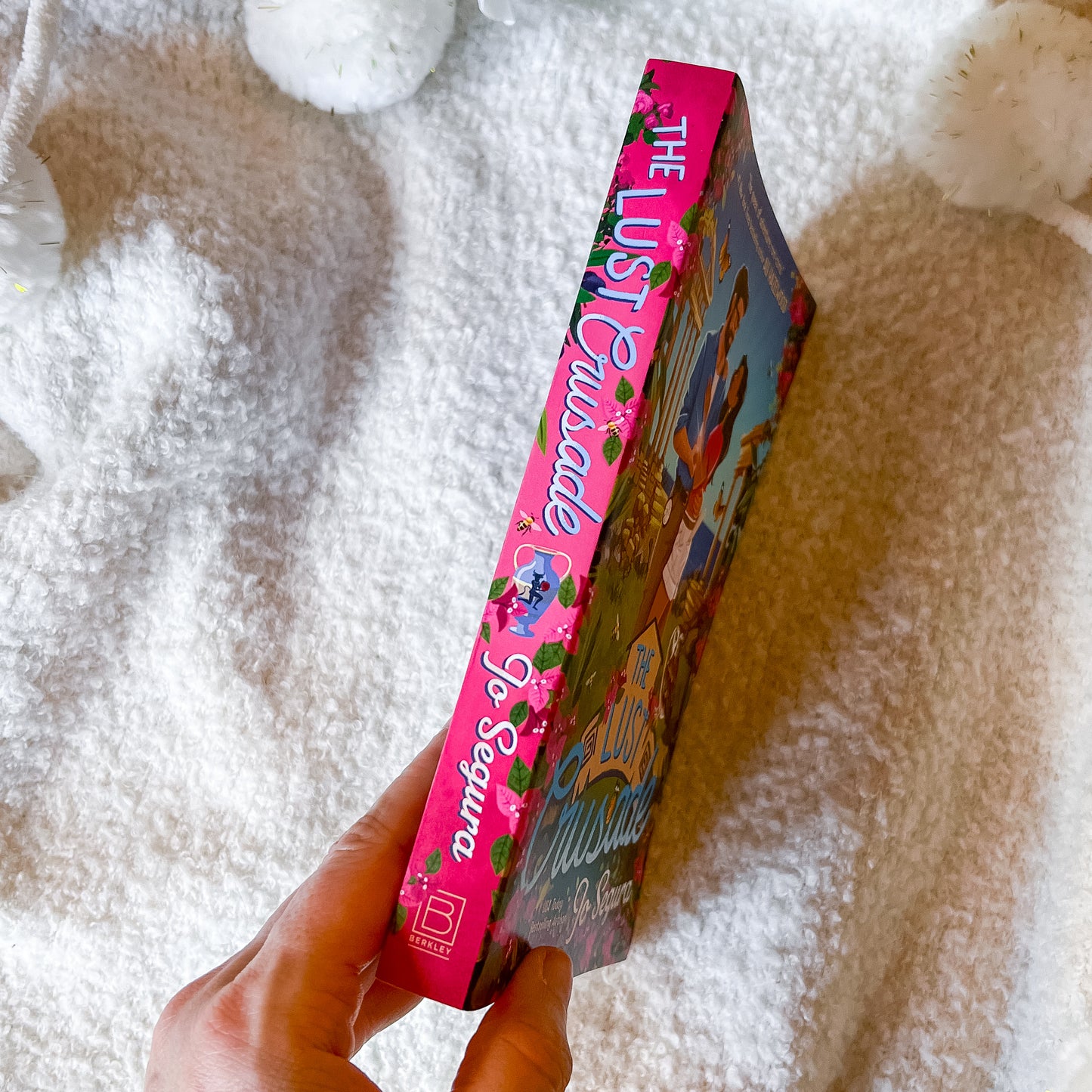 Book titled 'The Lust Crusade' held by a hand on a textured surface