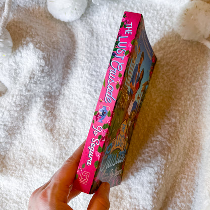 Book titled 'The Lust Crusade' held by a hand on a textured surface