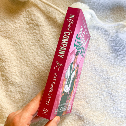 Book titled 'Good Company' by KAT Singleton held against a textured beige background