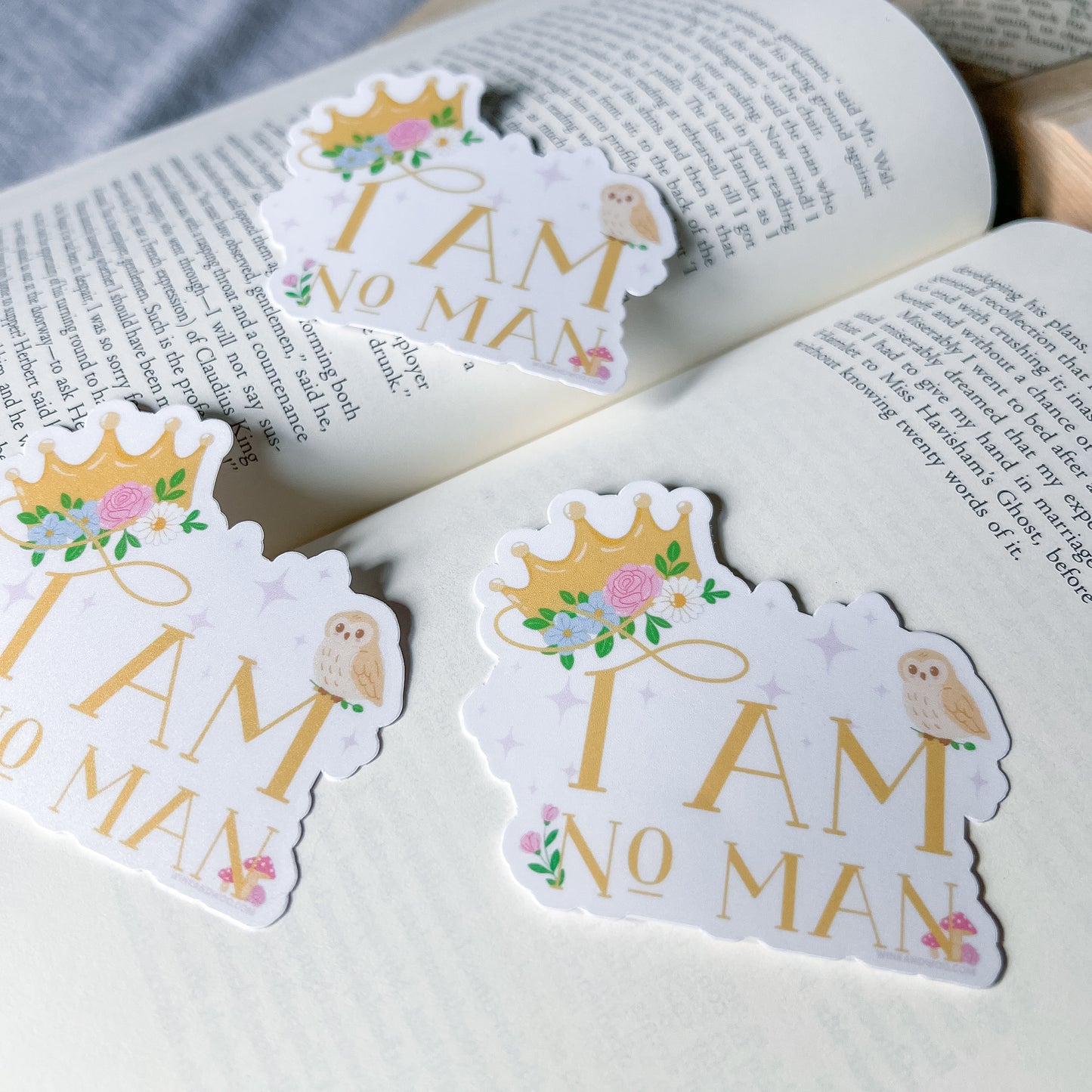 Stickers with 'I AM NO MAN' text on a book