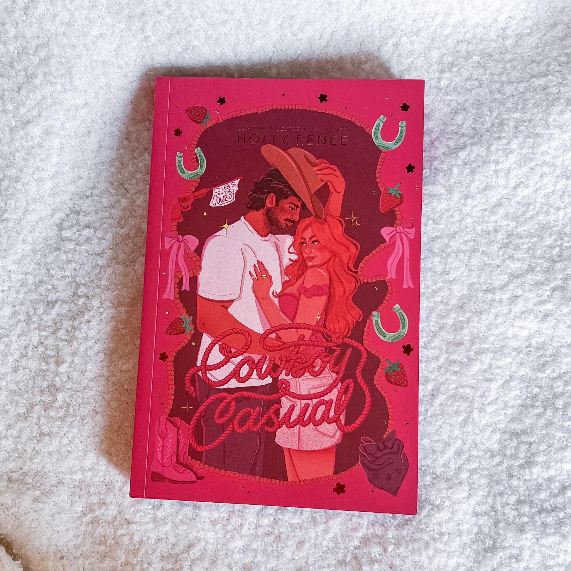Book titled 'Cowboy Casual' with a red cover featuring illustrations of a couple on a textured white surface.